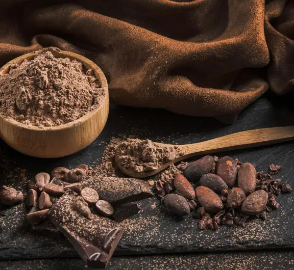Un cuenco de madera rústico lleno de polvo de cacao fino de color marrón claro.